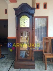 Lemari jam minimalis dengan bahan material kayu jati motif ukiran Jepara atau yang biasa disebut dengan almari minimalis jam dengan mesin junghan